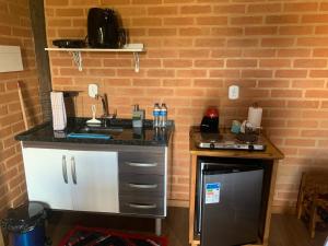 a small kitchen with a sink and a counter at chalés Roma in Santo Antônio do Pinhal
