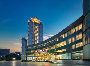 a large building with a sign on top of it at Crowne Plaza Taizhou by IHG in Taizhou