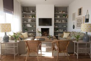 sala de estar con sofá, sillas y chimenea en Living4Malaga Monte Sancha Deluxe View, en Málaga