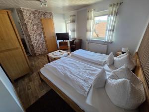a bedroom with a large white bed and a window at Pension ohne Frühstück in Gößweinstein