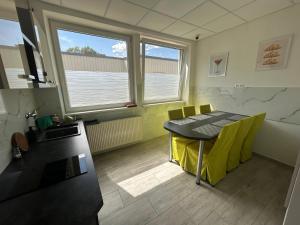 a kitchen with a table and yellow chairs in a room at Penzion Teplanka in Považská Bystrica