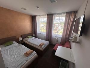 a small room with two beds and a window at Penzion Teplanka in Považská Bystrica