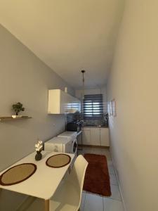 a small kitchen with a white table and chairs at Dimi's home in Komotini +6 photos