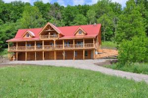 a large log home with a red roof at Lodge Solange in Palatine Bridge