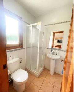 a bathroom with a shower and a toilet and a sink at Villa Mar in Cala en Bosc +3 photos