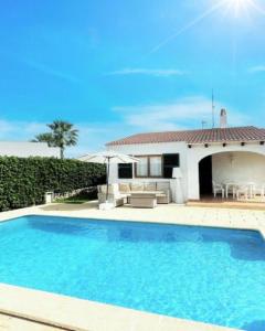 a swimming pool in front of a house at Villa Mar in Cala en Bosc