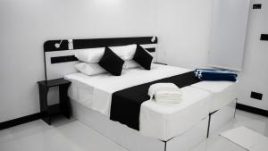 a bedroom with a black and white bed with pillows at Alyraa Sunset Mathiveri - Free Picnic Island Trip Included in Mathiveri