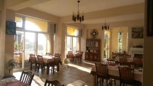 a dining room with tables and chairs and a clock at Cenacle B & B in Chenggong