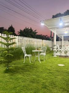 a table and chairs in a yard at night at สังข์เงินรีสอร์ท2 in Nakhon Sawan