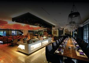 a dining room with a long table and chairs at Blue Sky Hotel Balikpapan in Balikpapan