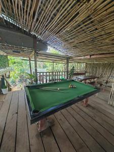 a green pool table on a wooden deck at Happy Elephant Bungalows in Senmonorom