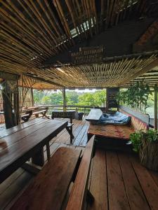 a wooden deck with benches and tables on it at Happy Elephant Bungalows in Senmonorom