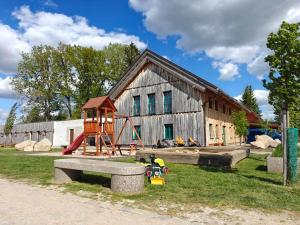 a wooden barn with a playground and a play structure at Ranč Telč in Telč