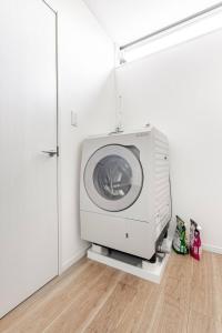 a washing machine in a room with a door at yuanquanHOTEL in Osaka