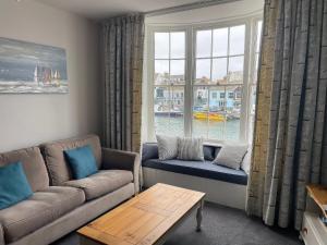a living room with a couch and a window at Safe Harbour in Weymouth