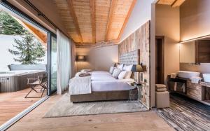 ein Schlafzimmer mit Bett und ein Badezimmer mit Badewanne in der Unterkunft Hotel Montchalet in St. Ulrich in Gröden + 75 Fotos
