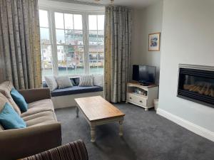 a living room with a couch and a tv at Safe Harbour in Weymouth