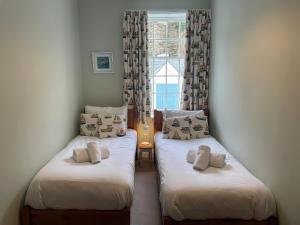 two twin beds in a room with a window at Safe Harbour in Weymouth