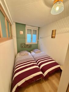 two beds in a room with green and white walls at Central Océan in Les Sables-d'Olonne