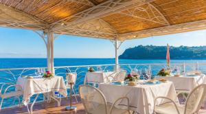 a group of tables and chairs on a boat at Hotel Ipomea Club in Capo Vaticano