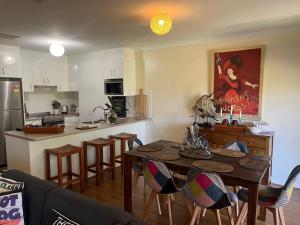 a kitchen and dining room with a table and chairs at 225 on Myall in Tea Gardens