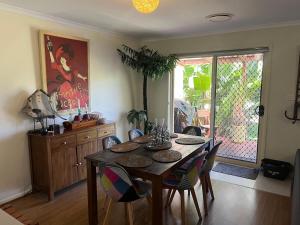 a dining room with a wooden table and chairs at 225 on Myall in Tea Gardens +9 photos