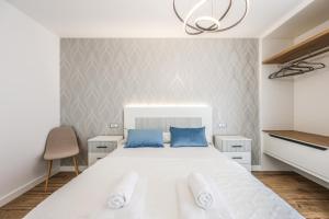 a bedroom with a large white bed with blue pillows at Polán Living | New Apartment - B in Polán +85 photos