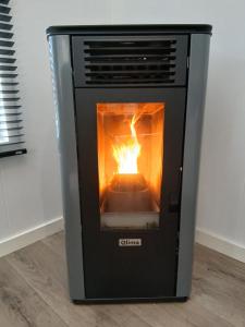 a stove with a fire inside of it at Luxe chalet voor gezinnen in familiepark Goolderheide met openlucht zwembaden en ruim overdekt terras 24m2 in Bocholt