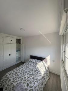 a bedroom with a bed and white cabinets at La calma de Aisheric in Nigrán