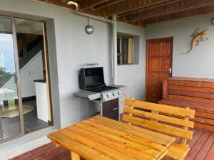 a wooden bench sitting on a porch with a stove at Wilderness Escape with breathtaking Views in Wildernis