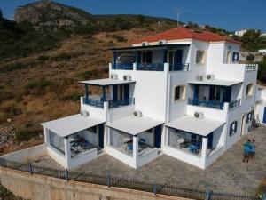 a large white house on top of a hill at Απεραντο Γαλαζιο in Agia Pelagia