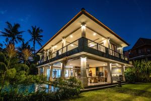 a villa with a swimming pool at night at Sunset Pandawa Villa in Ubud