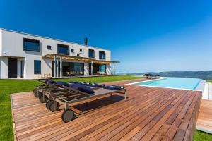 Una casa con terraza con salones y piscina. en Villa Vista Zamask, en Zamask