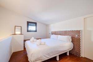 a white bed with two pillows on it in a room at Flateli Santa Clara 31 in Girona
