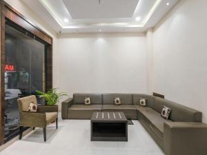 a living room with a couch and a table at Hotel Anchal Villa By YB Hotel in Udaipur