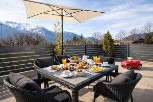 a table with food and a red car in the background at Seelos - Alpine Easy Flats in Mieming