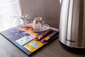 a table with a book and glasses and a bottle of wine at Four Side Hotel in Prishtinë