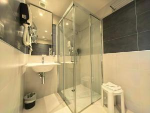 a bathroom with a glass shower and a sink at La Dolce Vita Hotel in Menton +79 photos