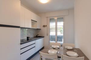 a kitchen with a table and chairs in a room at Les Fleurs Pool Residence in Bordighera