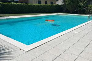 a swimming pool with a red toy in the water at Les Fleurs Pool Residence in Bordighera