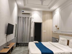a bedroom with a large bed and a television at Hotel Indo Tiger by RawatHospitality in Tembhuida