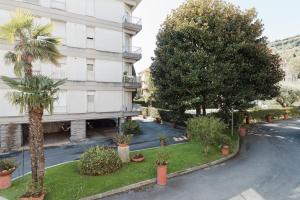 a building with palm trees and plants in front of it at Les Fleurs Pool Residence in Bordighera