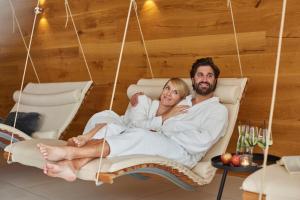 a man and a woman sitting in a swing at Wiedemann's Weinhotel in Sankt Martin