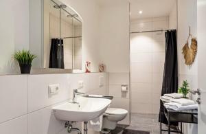 a white bathroom with a sink and a toilet at Mina in Geratskirchen