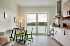 a kitchen with a table and green chairs in a room at Mina in Geratskirchen