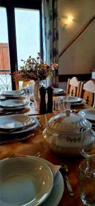 a wooden table with plates and dishes on it at Auberge de l'eau rousse in La Léchère