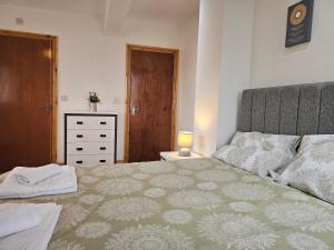 a bedroom with a large bed and a dresser at Spacious 3-Bedroom House Near Leeds City Centre By Homebird Property Management Short Lets & Serviced Accommodation Leeds With En-Suite Bathrooms & Free Parking in Leeds +21 photos