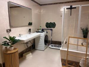 a bathroom with a sink and a washing machine at Luga Homes - Augustusplatz in Leipzig +31 photos