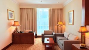 a living room with a couch and chairs in a hotel room at Sunday Hotel Al Barsha Dubai Mall of the Emirates Formerly Grand Excelsior Al barsha in Dubai