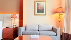 a living room with a couch and a table at Sunday Hotel Al Barsha Dubai Mall of the Emirates Formerly Grand Excelsior Al barsha in Dubai +89 photos